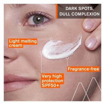 Close-up of woman applying Uriage Depiderm Anti-Brown Spot Cream SPF50+ on cheek, emphasizing light melting texture, fragrance-free formula, and very high SPF protection