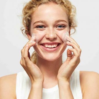 Model cleansing face with Isdin Everclean Purifying Gel foam