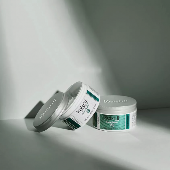 Reistill Keratin Complex Hair Mask jars arranged on a light grey surface under soft studio light, professional hair repair treatment